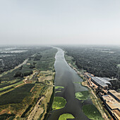 Luftaufnahme des Kaliganga-Flusses, der durch üppiges Ackerland und Grünflächen fließt, Baniajuri, Ghior, Dhaka, Bangladesch.