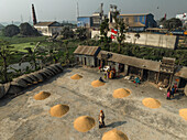 Sarail, Bangladesch - 31. Januar 2025: Luftaufnahme von Reismühlen und Feldern mit arbeitenden Menschen in einer ländlichen Landschaft, Uttar Panisar, Chattogram, Bangladesch.