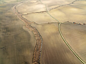 Luftaufnahme von ruhigem Ackerland mit landwirtschaftlichen Feldern und ruhigen Landschaftsmustern, Campina Cordobesa, Cordoba, Spanien.