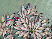 Aerial view of colorful boats on the Buriganga River amidst the bustling city of Dhaka, Dhaka, Bangladesh.