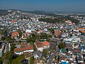 Luftaufnahme einer pulsierenden Stadtlandschaft mit dichter Wohnbebauung und malerischen Hügeln, Ward 4, Da Lat, Lam Dong, Vietnam.
