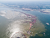 Luftaufnahme von Menschen, die sich zur Prayag Kumbh Mela entlang des Yamuna-Flusses versammeln, einem heiligen Fest für Gläubige in Triveni Sangam in Prayagraj, Uttar Pradesh, Indien.