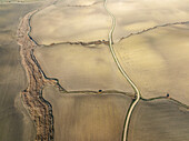 Luftaufnahme von ruhigem Ackerland mit geometrischen Mustern und goldenen Feldern, Campina Cordobesa, Cordoba, Spanien.