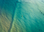 Luftaufnahme von Paddelboardern auf klarem, blauem Wasser in einem ruhigen Ozean, Port Noarlunga, South Australia, Australien.