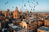 Aerial view of beautiful historic architecture and vibrant rooftops in sunset, Valletta, Malta.