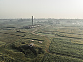 Luftaufnahme von Ziegelfeldern und einer Fabrik inmitten von Ackerland und Grünflächen, Paikar Char, Narsingdi, Dhaka, Bangladesch.