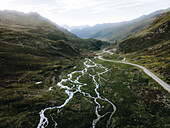 Aerial view of serene alpine landscape with majestic mountains, picturesque valley, and winding river, Davos, Kanton Graubunden, Switzerland.