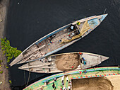 Luftaufnahme von geschäftigen Booten und Menschen, die entlang des Buriganga-Flusses mit Zementindustrie arbeiten, Darus Salam Thana, Dhaka, Bangladesch.