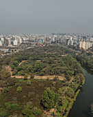 Luftaufnahme einer Stadtlandschaft mit modernen Gebäuden, Grünanlagen und einem Fluss, Mohammadpur Upazila, Dhaka, Bangladesch.