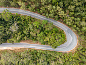 Luftaufnahme einer kurvenreichen Straße durch üppige Wälder und Grünanlagen, Boeng Tuk, Tuek Chhou District, Kampot, Kambodscha.
