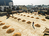 Ashuganj, Bangladesh - 31 January 2025: Aerial view of rice mills and fields with people working in a rural landscape, Paschim Talsahar, Ashuganj, Chattogram, Bangladesh.