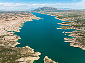 Aerial view of negratin reservoir surrounded by tranquil mountains and blue water, Cuevas del Campo, Granada, Spain.