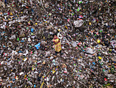 Chittagong, Bangladesh - 04 October 2022: Aerial view of a child working on a dirt hill surrounded by garbage in a polluted environment, Chittagong, Chittagong, Bangladesh.