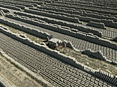 Aerial view of brick fields and factory with people engaged in manual labor, Suti Para Union, Dhamrai, Dhaka, Bangladesh.