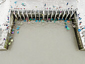 Aerial view of colorful fishing nets and bustling water ghat with fishermen and fishing traps, Mirsarai, Chittagong, Bangladesh.