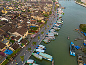 Aerial view of vibrant traditional architecture and bustling boats on the river in the historic town, Minh An, Quang Nam, Vietnam.