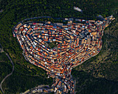 Aerial view of historic medieval old town with beautiful stone houses and winding alleyways on a hillside surrounded by greenery, Rotondella, Matera, Italy.