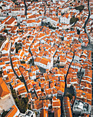 Aerial view of picturesque Alfama with vibrant orange rooftops and historic buildings, Lisbon, Lisbon, Portugal.