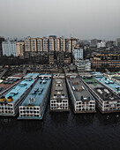 Luftaufnahme von Sadar Ghat und dem belebten Buriganga-Fluss mit zahlreichen Booten und städtischer Skyline, Aganagar, Keraniganj, Dhaka, Bangladesch.