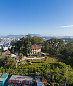 Luftaufnahme der Kaiserresidenz Bao Dai, umgeben von üppigem Grün und Bergen unter blauem Himmel, Ward 1, Da Lat, Lam Dong, Vietnam.