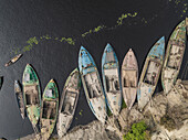 Aerial view of people working on wooden boats in a clear river near cement industries, Amin Bazar, Savar, Dhaka, Bangladesh.