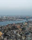 Luftaufnahme des belebten Sadar Ghat entlang des schönen Buriganga-Flusses mit Stadtbild und Booten, Aganagar, Keraniganj, Dhaka, Bangladesch.