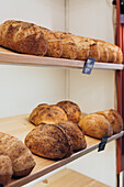 In a cosy bakery, freshly baked loaves of bread rest on wooden shelves. The warm, golden crust promises a satisfying crunch with every bite