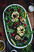 A colourful salad with avocado, blackberries, cherries, fresh greens and nuts, garnished with a drizzle of balsamic glaze. Perfect for a healthy meal.