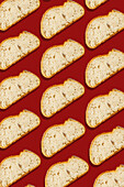 A seamless pattern of diagonally arranged slices of bread on a bright red background Perfect for culinary designs and food-related projects