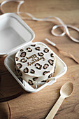 Charming mini birthday cake with trendy leopard print in a white box to take away, perfect as a gift for a special occasion.
