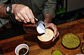 A barista carefully pours steamed milk into a latte to create an artistic latte art. The scene captures the essence of speciality coffee and craftsmanship.