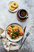 Enjoy a delicious breakfast with an omelette made from chicken eggs, tomatoes and cheese, fried in olive oil, along with black coffee and butter biscuits for a balanced meal