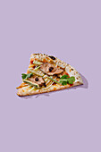 Gourmet pizza slice with sous-vide cooked duck fillet, secret international sauces such as nut sauce, leek, cucumber, coriander and mozzarella cheese on a handmade crust against a purple background