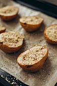 Delicious arrangement of halved pears filled with creamy dor bleu cheese and sprinkled with crushed nuts, arranged on a baking tray with parchment paper.