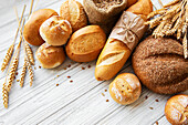 Assortment of baked bread on a white wooden background
