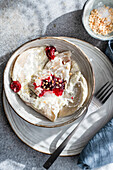 Traditionelle ukrainische Varenyky, gefüllt mit Kirschen, serviert mit cremiger saurer Sahne und bestreut mit gehackten Nüssen. Eine köstliche und authentische osteuropäische Leckerei.