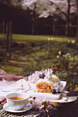 A decadently filled Swiss roll with dulce de leche, served for tea at a garden table surrounded by blooming spring flowers.