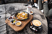 A cosy table on the Geisleralm in the Dolomites, Italy Traditional dishes such as Kaiserschmarrn are served on a rustic wooden table, paired with coffee and mountain views
