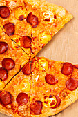 Close-up of a freshly baked pepperoni pizza on a box The golden crust and melted cheese create an inviting and appetising look, perfect for a cosy meal at home