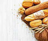 Assortment of baked bread on a white wooden background