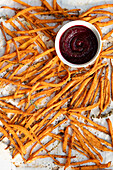 Baked, spiced sweet potato sticks with bright beetroot ketchup - perfect as a starter, snack or unique side dish