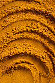 A vibrant close-up of golden curry powder, showing the textured surface with swirling patterns This aromatic spice is perfect as an ingredient for cauliflower curry soup and more