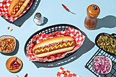 Overhead shot of hot dogs in baskets, served with ketchup and mustard on a bright blue background