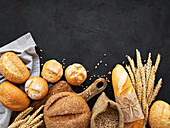 Assortment of baked bread on a black concrete background