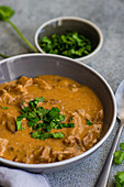 Delicious beef stroganoff with tender slices of meat in a rich, creamy sauce, served with fresh coriander, which enhances the vibrant flavour and aroma of the dish