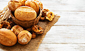 Assortment of baked bread on a white wooden background