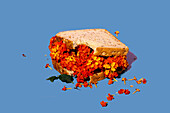 A whimsical sandwich with bright red and yellow flowers against a striking blue background that emphasises creativity and the fusion of nature and culinary art.