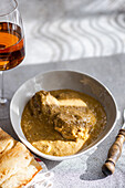 A classic Georgian dish, satsivi, with chicken in a rich walnut sauce, elegantly served with a glass of rare amber wine and freshly baked bread, from above.