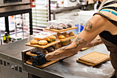 A baker prepares pastry boxes full of Italian delicacies Behind the counter, fresh pastries are neatly stacked, emphasising the charm of the Italian bakery