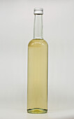 Eine hohe, klare Glasflasche, gefüllt mit Holunderblütensirup, verschlossen mit einer Metallkappe, vor einem schlichten weißen Hintergrund, ideal für die Präsentation von Produkten oder Getränken.